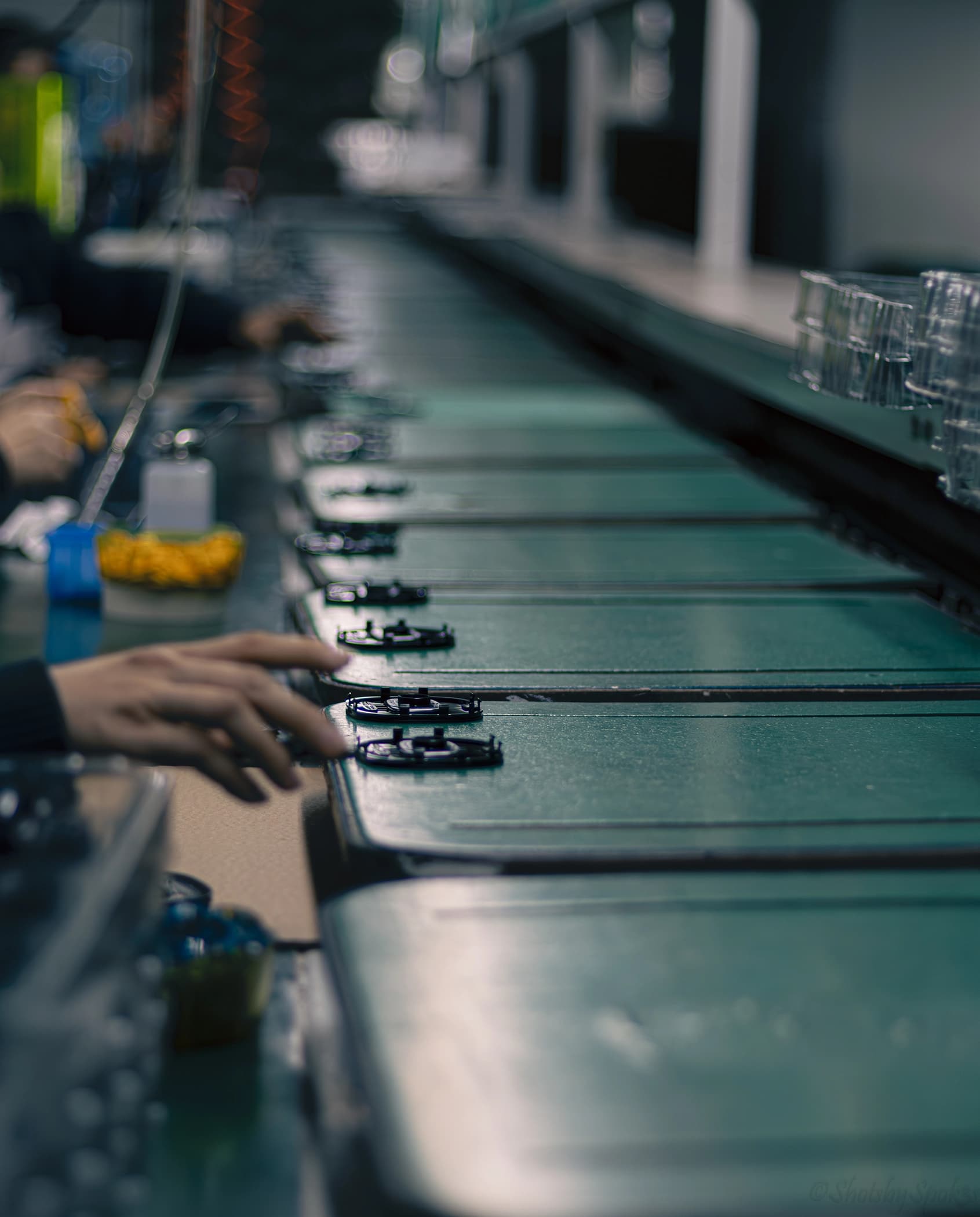 Hands assembling components on a production line