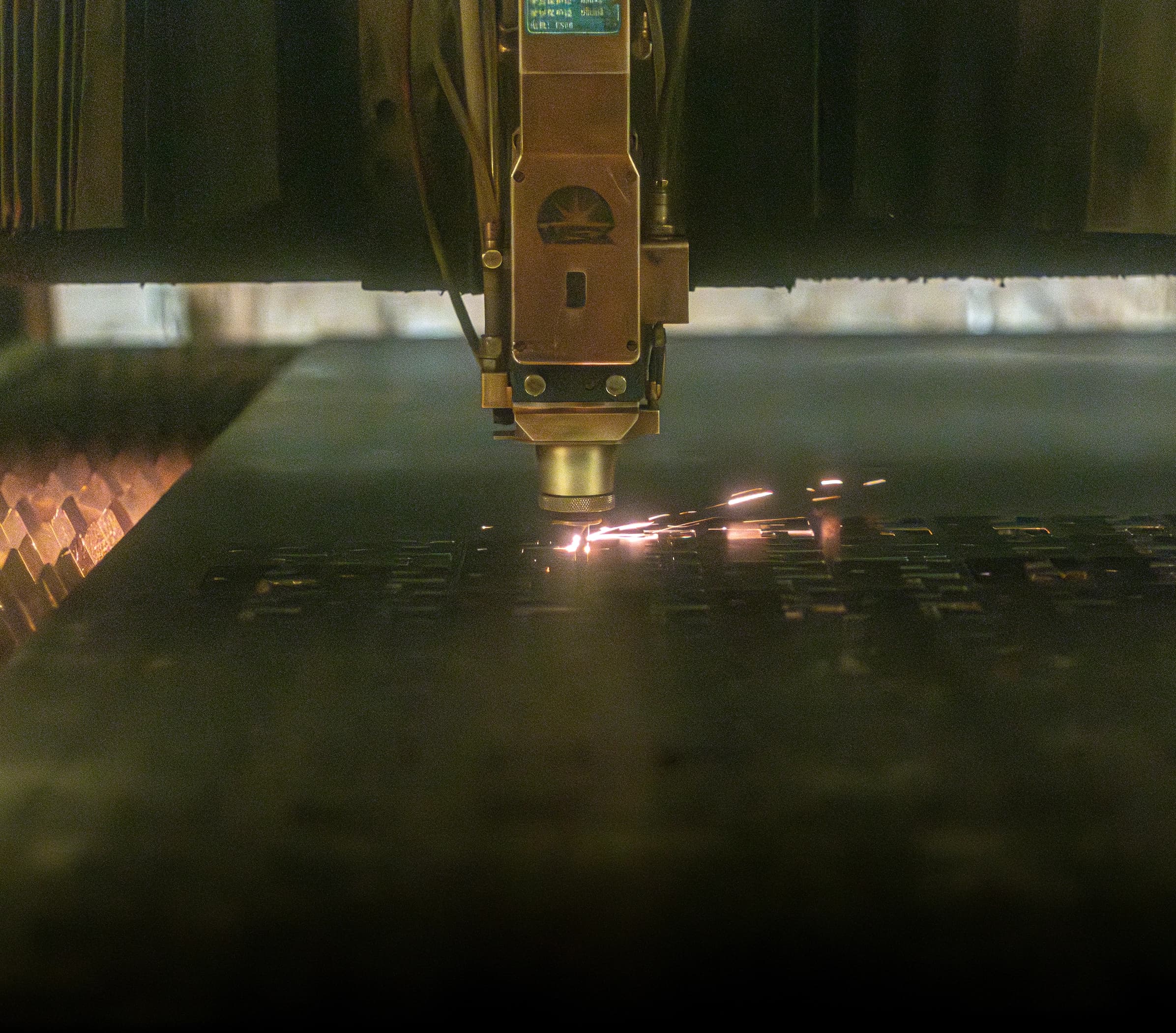 Laser cutting operation with sparks on metal sheet